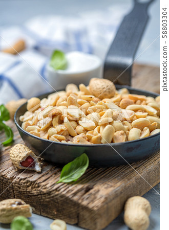 Roasted peanuts with salt in the pan. 58803304
