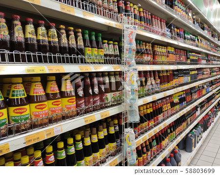 Selective focused variety of cooking sauce in the bottles displayed for sale in the supermarkets. Displayed on racks and separated by the brand to facilitate buyers. Selective focused variety of cooking sauce in the bottles displayed for sale in the supermarkets. Displayed on racks and separated by the brand to facilitate buyers. 58803699