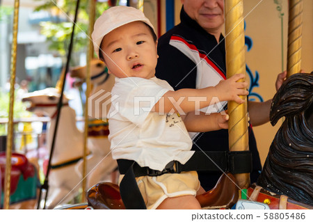 Cute boy riding a merry-go-round 58805486