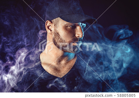 Brutal bearded man vaping and releases a cloud of vapor Brutal bearded man vaping and releases a cloud of vapor 58805805