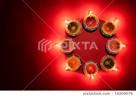 Happy Diwali - Clay Diya lamps lit during Hindu celebration 58809076