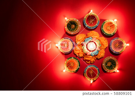 Happy Diwali - Clay Diya lamps lit during Hindu lights celebration 58809101
