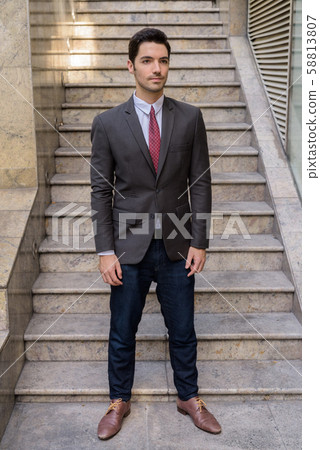 Portrait of young handsome businessman wearing suit in city Portrait of young handsome businessman wearing suit in city 58813807