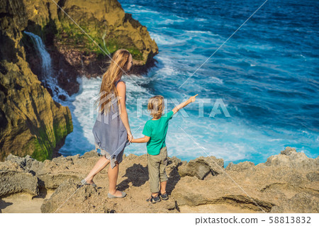 mother and son tourists against the background of the sea Angel's Billabong in Nusa Penida, Bali mother and son tourists against the background of the sea Angel's Billabong in Nusa Penida, Bali 58813832