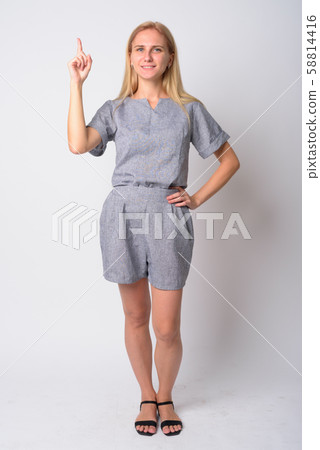 Full body shot of happy young blonde woman pointing up 58814416