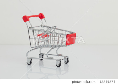 Miniature shopping cart and basket on white Miniature shopping cart and basket on white 58815871