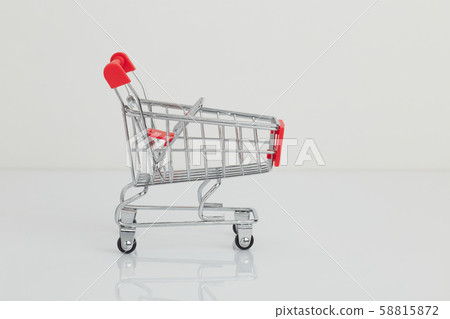 Miniature shopping cart and basket on white Miniature shopping cart and basket on white 58815872