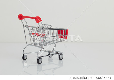 Miniature shopping cart and basket on white Miniature shopping cart and basket on white 58815873