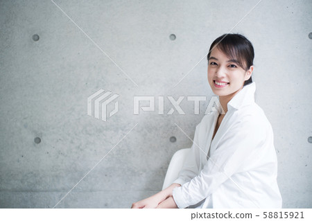 A young woman sitting on a chair A young woman sitting on a chair 58815921
