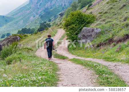 Back view male hiker walks in beautiful mountains in North Caucasus 58818657