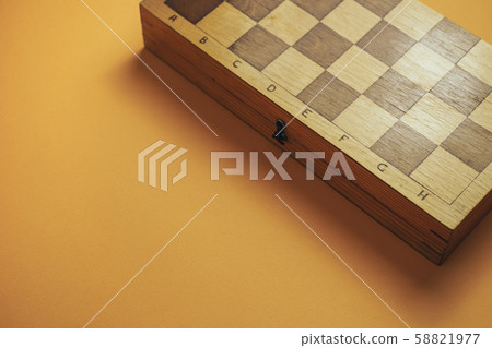 Beautiful old chess board on a orange background. 58821977