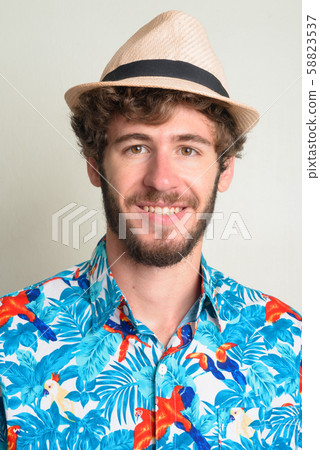 Face of happy young bearded tourist man with hat smiling Face of happy young bearded tourist man with hat smiling 58823537