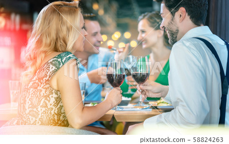People in a restaurant eating and drinking red wine People in a restaurant eating and drinking red wine 58824263