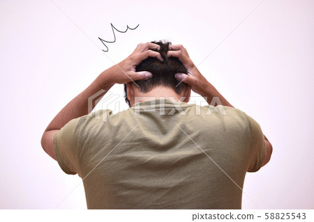 The back of a shocked man holding his head The back of a shocked man holding his head 58825543