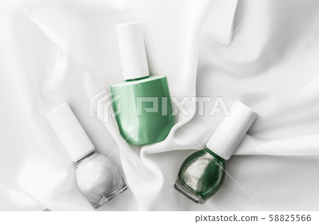 Nail polish bottles on silk background, french 58825566