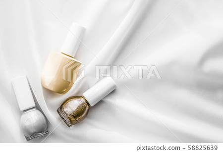 Nail polish bottles on silk background, french Nail polish bottles on silk background, french 58825639