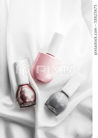 Nail polish bottles on silk background, french 58825675