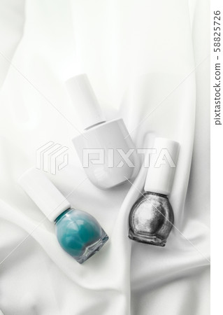 Nail polish bottles on silk background, french Nail polish bottles on silk background, french 58825726