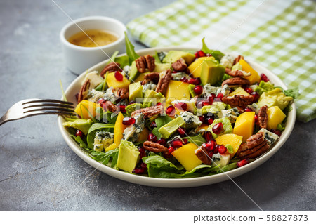 Arugula salad with mango, pomegranate, avocado, pecan nuts and blue cheese. Arugula salad with mango, pomegranate, avocado, pecan nuts and blue cheese. 58827873