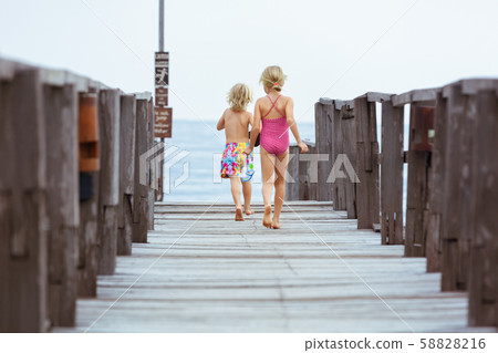 Kids with masks, fins going to snorkel in tropical 58828216