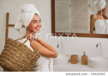 woman holding wicker basket with laundry 58828487