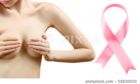 Young woman holds breast in hands near big pink ribbon. 58830050