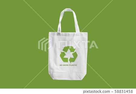 white cloth bag with Recycle sign logo and words "No more Plastic"  on green blackground.eco friendly concept 58831458