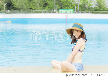 一個女人坐在游泳池旁 58833716