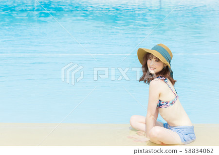 A woman sitting by the pool A woman sitting by the pool 58834062