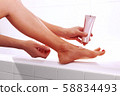 woman applying cream on foot 58834493