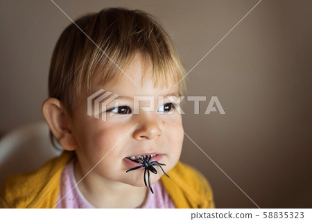 Portrait of toddler child with spider toy or candy. Halooween season activities 58835323