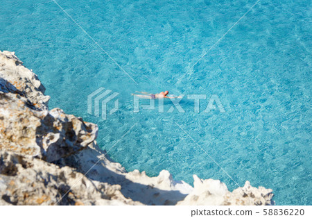 Men swiming in the shore of Torre dell'Orso 58836220