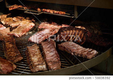 Pork ribs and kebabs grilled on a round grill Pork ribs and kebabs grilled on a round grill 58836392