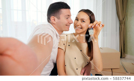 happy couple makes selfie with keys to amazing new house 58837744