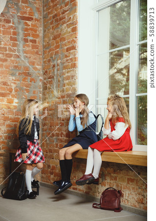 Group of kids spending time after school together. Handsome friends resting after classes. Group of kids spending time after school together. Handsome friends resting after classes. 58839713
