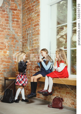 Group of kids spending time after school together. Handsome friends resting after classes. Group of kids spending time after school together. Handsome friends resting after classes. 58839739