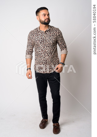 Full body shot of young bearded Indian man thinking 58840194