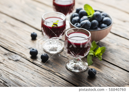 Sweet blueberry liqueur on the wooden table Sweet blueberry liqueur on the wooden table 58840760