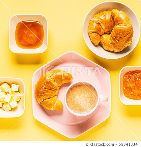 Coffee and croissants for breakfast on a yellow Coffee and croissants for breakfast on a yellow 58841334
