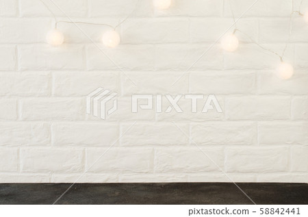 White brick wall with Christmas lights in the form of white balls. White brick wall with Christmas lights in the form of white balls. 58842441