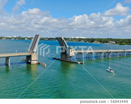 Aerial view of street bridge crossing ocean 58843449