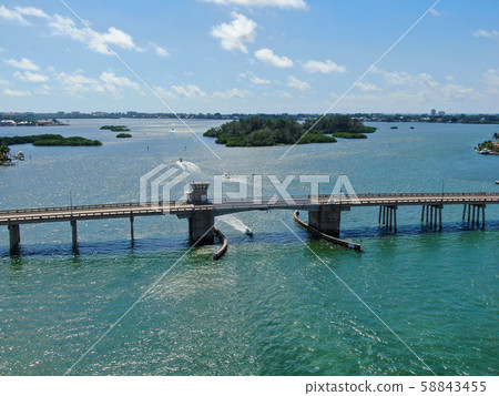 Aerial view of street bridge crossing ocean 58843455