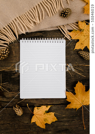 White blank notebook and pen on a dark background with a scarf, plaid and a cup, autumn yellow 58846019