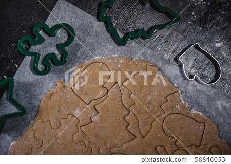 cut out gingerbread cookie in the form of a Christmas tree, star, little man, hearts from raw dough 58846053