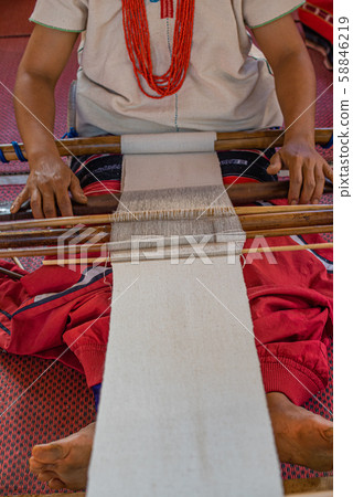 2.	Closeup of skillful hill tribe woman's hand doing colorful cotton cloth weaving. Show traditional textile production and simply way of life by self- reliance practice, Chiangmai Thailand. 58846219
