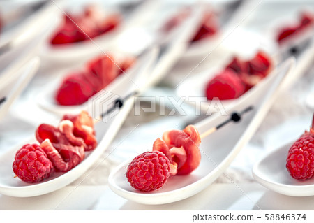 Delicious canapes hamon with raspberries. Concept of food, restaurant, catering, menu. 58846374
