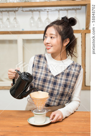 A woman in her twenties doing a hand drip 58848702