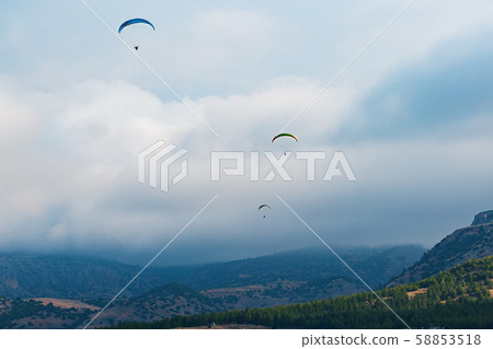 Paragliders couple on a background of clouds and 58853518