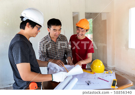 Engineer and architect discussing with foreman about project in building construction site 58856340