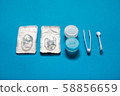 Blue color pair of contact lenses in blisters with blue contact lens case and tweezers on blue background 58856659